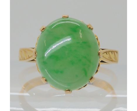 A 14K CHINESE GREEN HARDSTONE RING with engraved shoulders and heart pattern basket, approx dimensions of the hardstone 13.5m