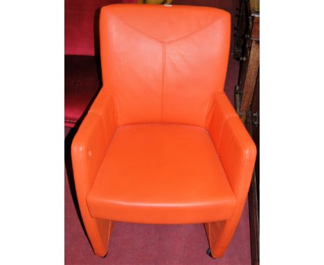 A pair of contemporary orange leather upholstered armchairs, each on roller castors