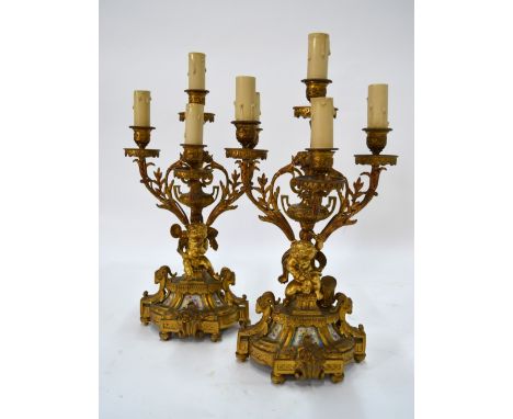 A good pair of 19th century French ormolu five-branch candelabra mounted with porcelain panels and rams' heads with drum-play