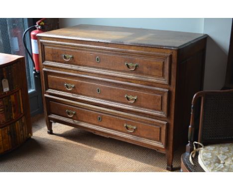 An 18th century oak continental commode, the plank top over three long drawers, raised on short square section block end legs