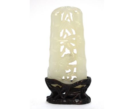 A small green jade of whitish hue; the reticulated design, carved as a long-tailed bird beside bamboo, 7 cm. high; with wood 