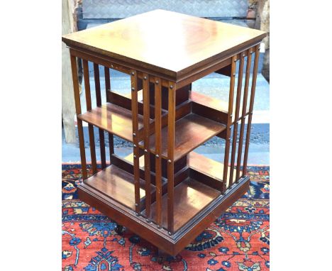 A late 19th century boxwood and ebony chequer edged red walnut revolving bookcase comprising eight compartments in two tiers,