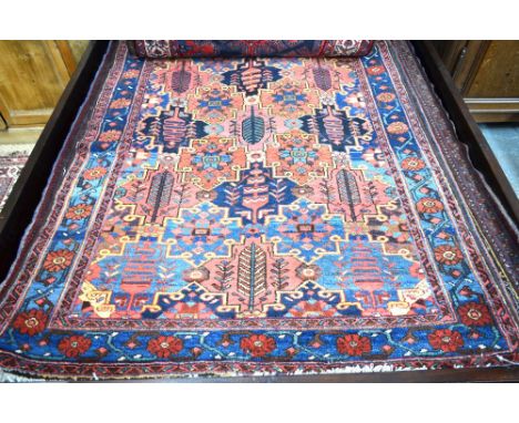 An antique Persian Bakhtar rug, the diamond tile floral design within repeating rosette border, 200 x 130 cm