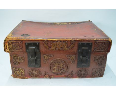 A Chinese red leather chest and cover of rectangular form, decorated with floral motifs and loop handles, 80 x 64 x 36 cm
Pro