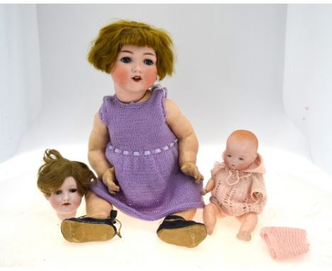 An Armand Marseille 995 SUR 11.5 cm bisque-headed girl doll with cropped brown wig, closing blue eyes, open mouth with two te
