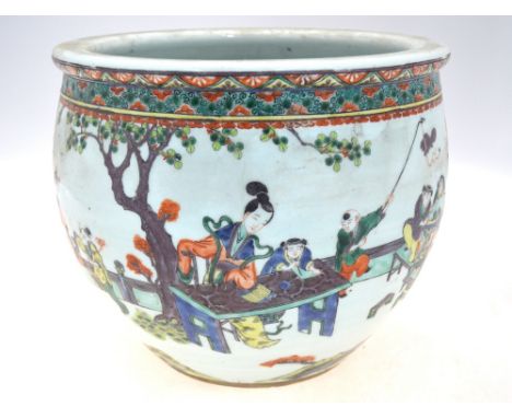 A famille verte planter or jardiniere, decorated with Manchu/Chinese figures at leisure, one lady practising her calligraphy,