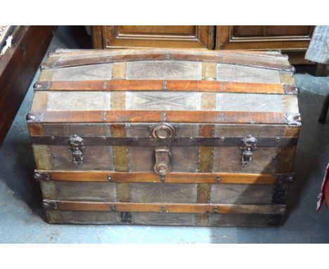 An antique tooled leather clad domed top trunk with tray to interior and leather carrying handles, 89 x 50 x 55 cm high