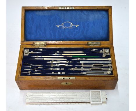 An Edwardian oak cased draughtsman's set with fitted lift-out trays, comprising nickel and ivory drawing instruments, boxwood