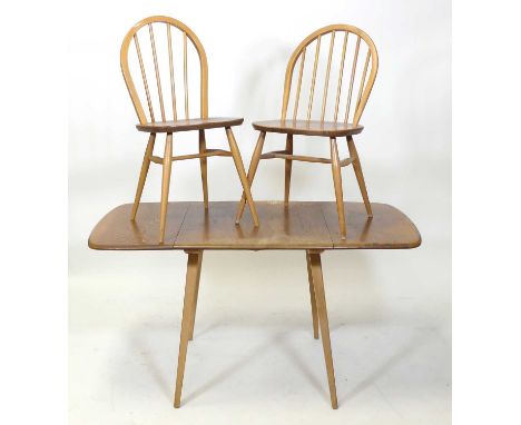 A 1960s Ercol blond elm and beech breakfast suite, comprising; drop-flap table with rounded corners raised on square tapering