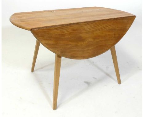 A 1960s Ercol blond elm 'Windsor' model 384 dropflap kitchen table, having opposing fall leaves, raised on slightly tapering 