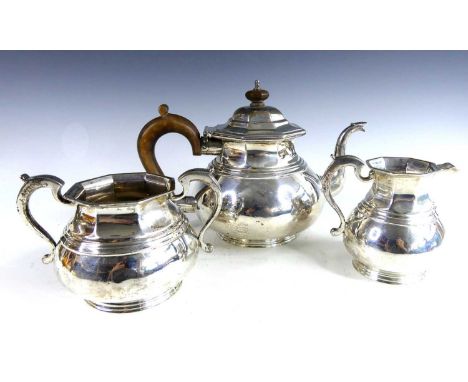 An early Art Deco silver three-piece tea service, comprising; teapot, twin handled sugar bowl and cream jug, each piece of lo