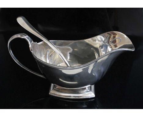 An Art Deco silver pedestal sauceboat, the otherwise plain body with repousse curved detail to the corners, having reeded loo