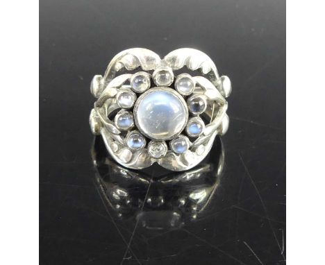 Georg Jensen (1866-1935) - a sterling silver and moonstone set dress ring, the central cabochon stone surrounded by ten small