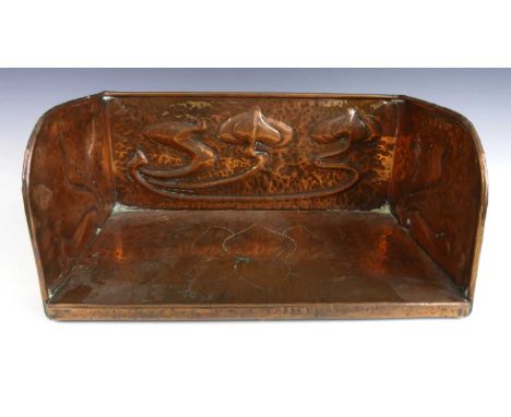 Attributed to Liberty &amp; Co - a circa 1900 repousse decorated and hammered copper book trough, with stylised floral decora