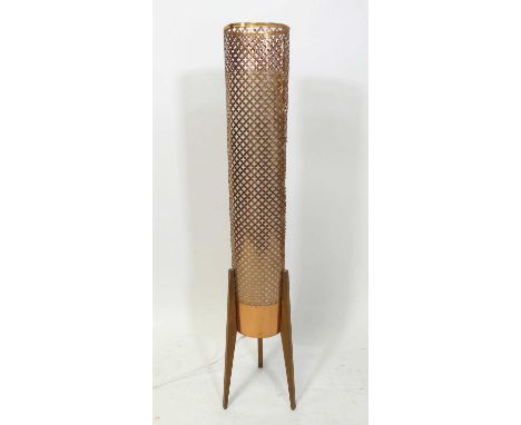 A 1960s teak rocket lamp, having a pierced copper cylindrical long shade, raised on slightly tapering supports, height 134cm
