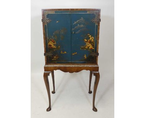 A 1930s walnut and blue chinoiserie lacquered double door drinks cabinet on stand, the cupboard doors decorated with figures 