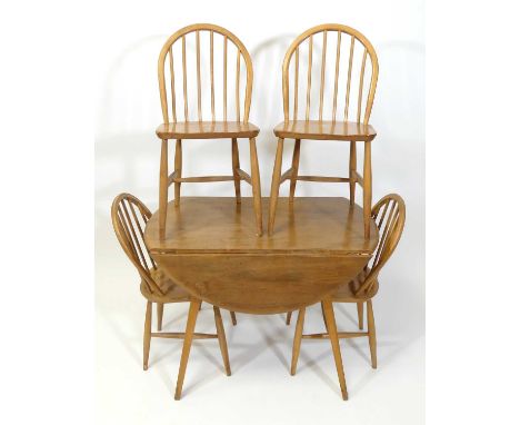 A 1960s Ercol blond elm 'Windsor' model 384 dropflap kitchen table, having opposing fall leaves, raised on slightly tapering 