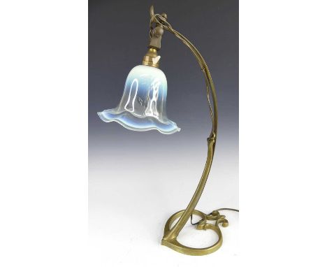 A French Art Nouveau brass table lamp, with curved elongated stem to leaf shaped pierced base, with vaseline domed frilly edg