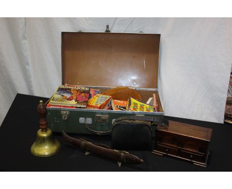 Board games, brass bell, knife and fork housed in a fish form scabbard, all housed in a tin suitcase (qty