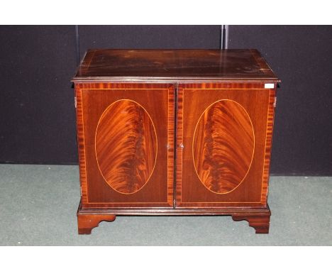 Mahogany veneered cupboard, with two simulated panelled cupboard doors opening to reveal an interior shelf, on bracket feet, 