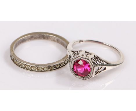 Two silver rings, the first with a ruby effect stone, the second an eternity ring, (2)