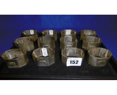 A SET OF TWELVE ART DECO OCTAGONAL ENGINE TURNED HALL MARKED SILVER NAPKIN RINGS WITH VACANT CARTOUCHES, BIRMINGHAM 1932