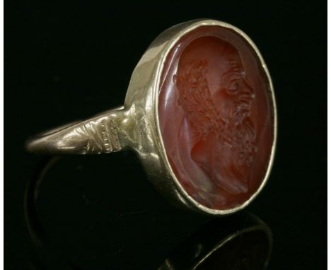 A cornelian intaglio engraved ring,  HBdepicting the bust of a bearded gentleman, rub set to a gold collet.  Hand engraved in