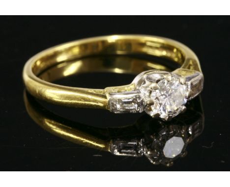 An 18ct gold single stone diamond ring,with baguette cut diamond shoulders.  A brilliant cut diamond, estimated as approximat