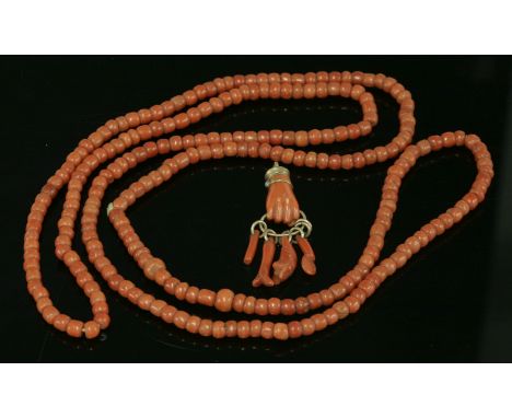 A single row uniform coral bead necklace,with barrel-shaped beads, 4.5 to 5mm, strung plain without a clasp, two longer beads