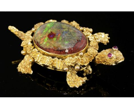 A gold boulder opal and ruby set novelty turtle brooch, c.1970,with a cabochon boulder opal rub set to the centre, with caboc