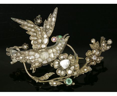 A diamond and gem set bird on a bough brooch,with an articulated wing, possibly Ottoman.  The bird grain set with graduated D