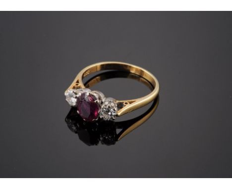 A ruby and diamond three stone ring,with an oval mixed cut ruby, claw set to the centre, and a brilliant cut diamond at eithe