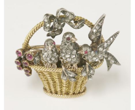 A diamond and ruby set 'birds in a basket' brooch,with a woven gold wicker-style basket with a twisted wire handle.  Pavé set