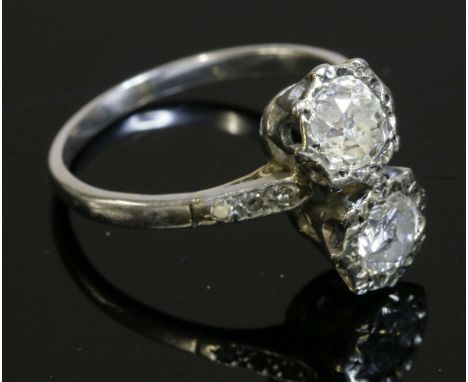 A two-stone diamond ring,with a cushion cut diamond and a brilliant cut diamond illusion set to rex collets in a fingerline p