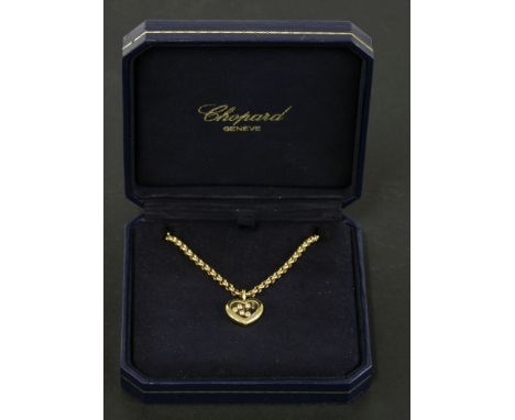 A Chopard 'Happy Diamonds' heart-shaped pendant,with five 'Happy Diamonds'.  A glazed compartment with five diamonds to a pol