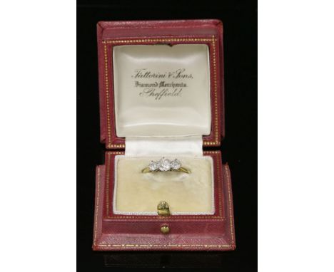 A graduated three stone diamond ring,with a central cushion cut diamond, estimated as approximately 0.56ct, and an old Europe