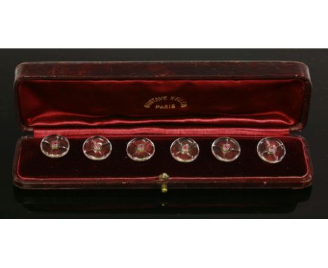 A cased set of six French crystal, gold and ruby buttons,by Gustave Keller, Paris, c.1890, the round carved crystal panels wi