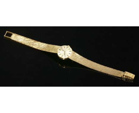 A ladies' 9ct gold Omega mechanical bracelet watch,with a circular silvered dial, raised batons and black hands.  An integral