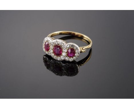 An Edwardian ruby and diamond triple cluster ring,with three graduated oval mixed cut rubies, all claw set to an outer border