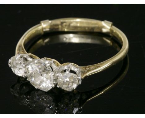 A three stone diamond ring,with an old European cut diamond, estimated as approximately 0.70ct, claw set to the centre.  A sm