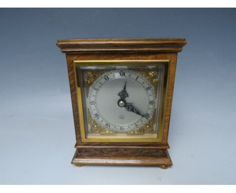 A WOODEN CASED ELLIOTT MANTLE CLOCK, raised on four brass bun feet, H 16.8 cm, W 13.5 cm, D 7 cm