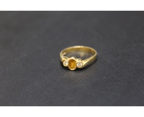 A HALLMARKED 18 CARAT GOLD RING, set with yellow sapphire type central stone and two small diamonds, approx weight 4.2g, ring