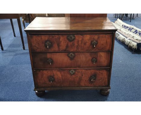 A Georgian Walnut Chest of Three Drawers of typical form raised on turned bobbin feet with brass mounts. Height 32 inches, wi