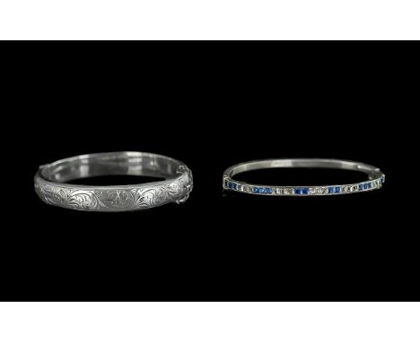 A Silver Hinged Embossed Bangle, with safety chain (needs reattaching), together with a slim silver hinged bangle set with bl