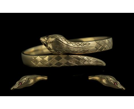 Ladies 9ct Gold Hinged Bangle in the form of a coiled snake with garnet set eyes, hallmarked London 1963, weight 19.8g, diame