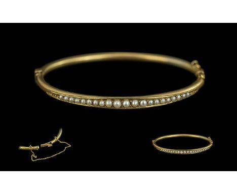 Victorian Period 9ct Gold Seed Pearl Set Hinged Bangle with safety chain, not marked but tests as gold; good condition in all