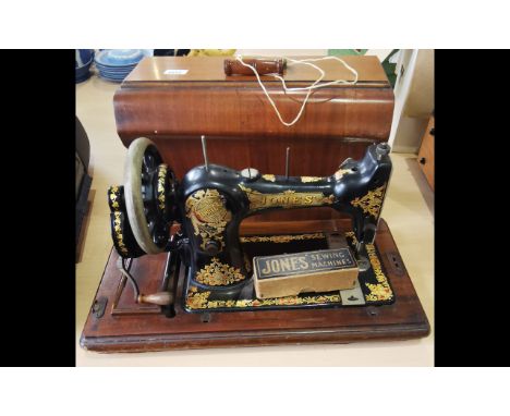 Vintage Jones Sewing Machine, black and gold design, housed in a wooden case with key.