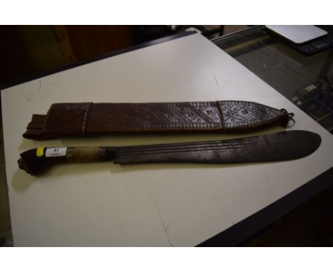 A machete contained in leather scabbard having unusual wooden handle carved with a shoe