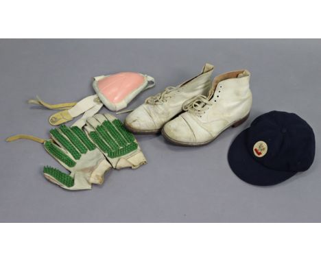 A pair of vintage cricketer’s shoes; a pair of wicket-keeper’s gloves; &amp; a peaked school cap.