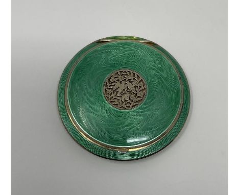 An Austrian silver guilloche and green enamel compact, the pierced top decorated flowers and birds, 9 cm diametersmall area o